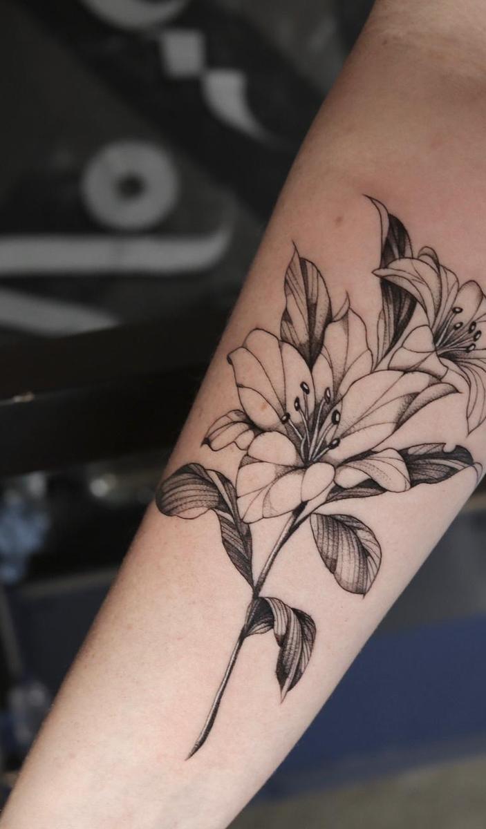 Tatuagem delicada de lírio no antebraço